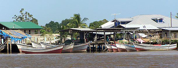 Little houses and fishing boats on the banks of the Surinam river